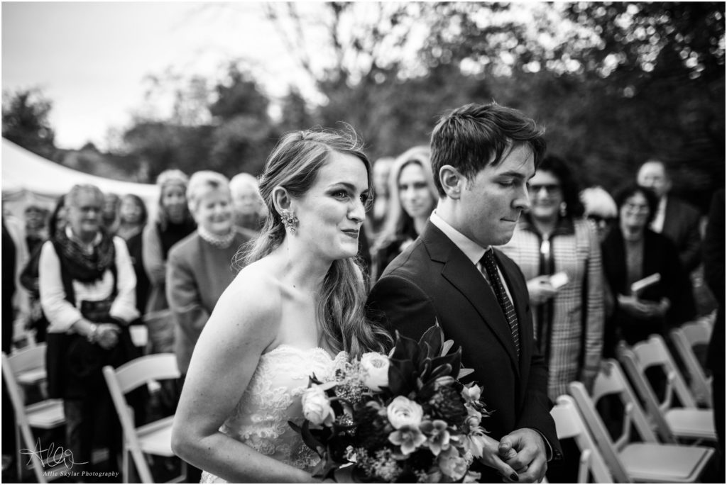 black and white emotional photo of bride walking down the aisle