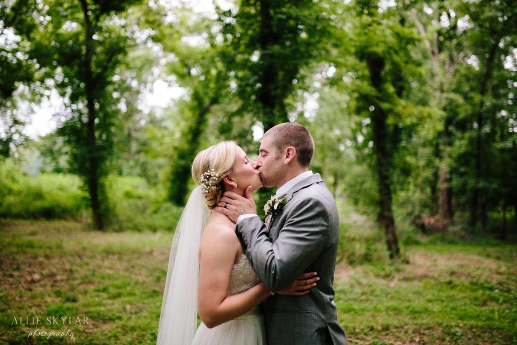 bride and groom kiss in the woods by Rupert Bridge in Bloomsburg PA