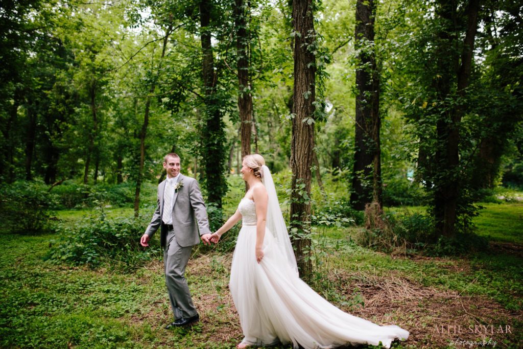 bride and groom walk in the woods by Rupert Bridge in Bloomsburg PA