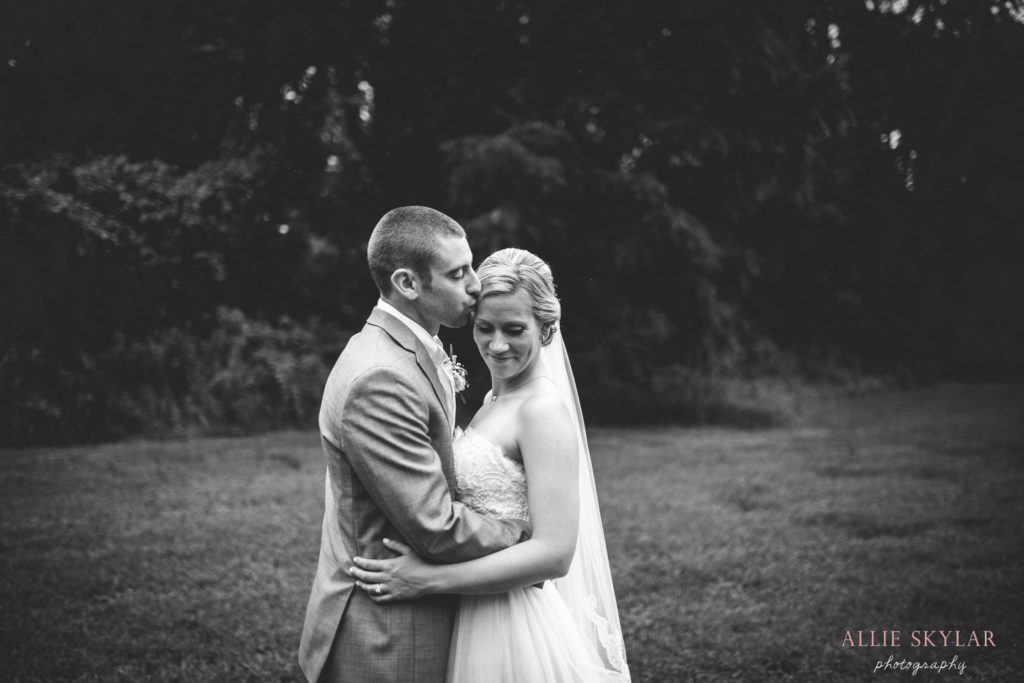 bride and groom embrace in a field at Barn at Boones Dam in Bloomsburg