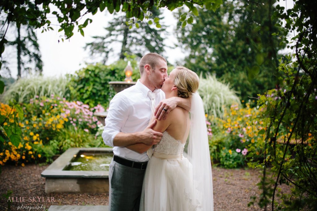bride and groom kiss in garden at barn at boones dam