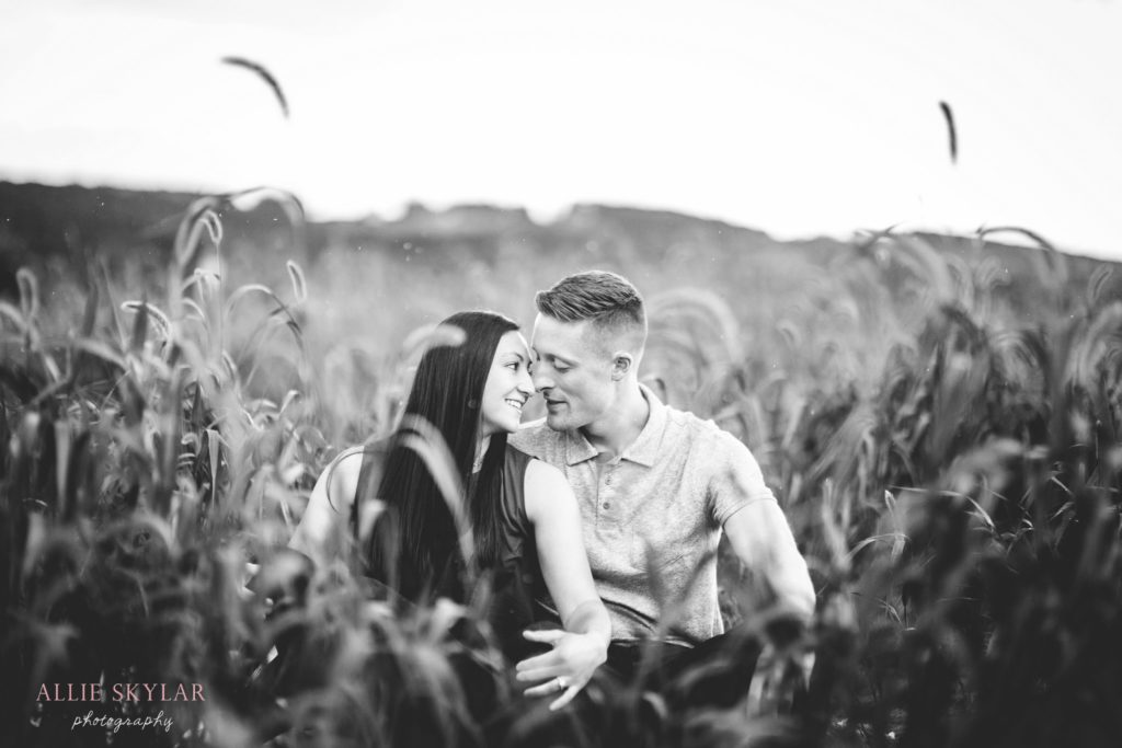couple-snuggle-in-field-at-farm-in-bloomsburg