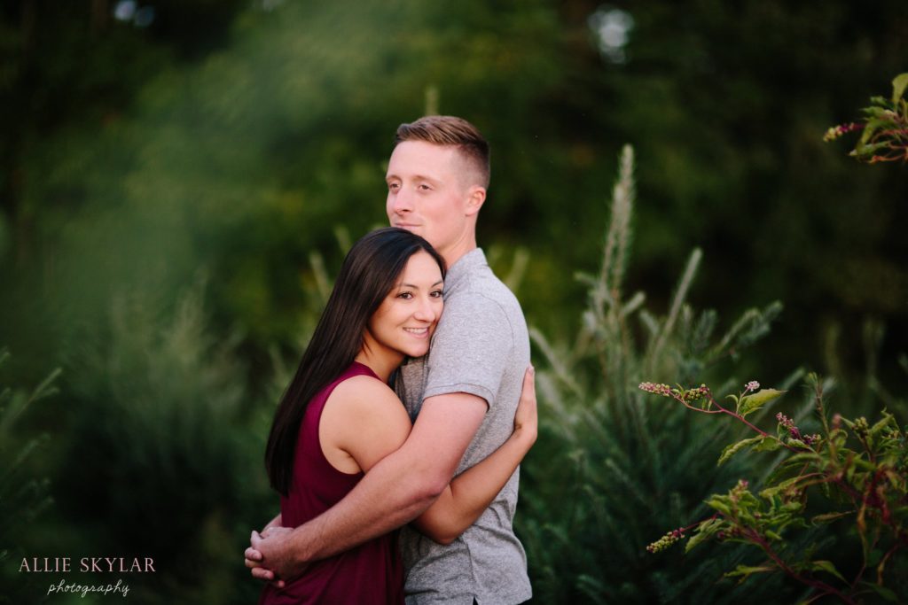 couple-embrace-in-christmas-tree-farm