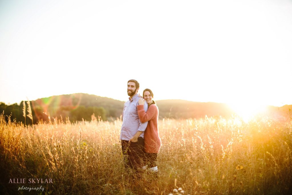 bride and groom to be pose at sunset in a field at valley forge park