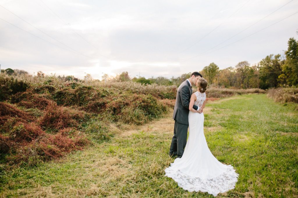 couple kiss in a field at peoples light and theater wedding