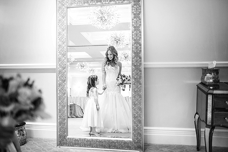 bride and flower girl look in the mirror