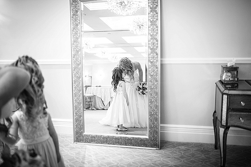 bride and flower girl look in the mirror