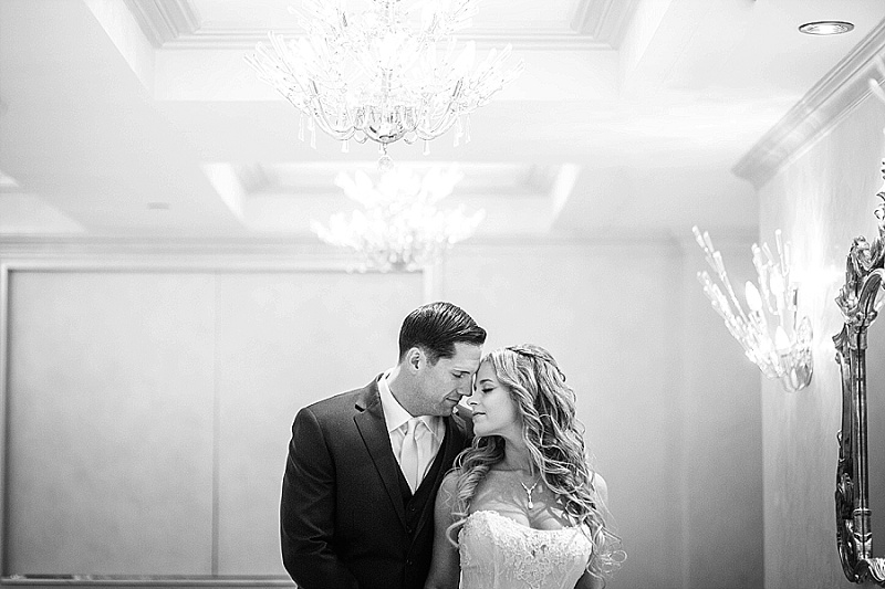 bride and groom embrace under a chandelier at The Grove NJ