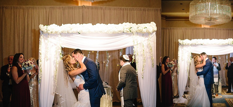 bride and groom kiss under the huppah at the Grove NJ