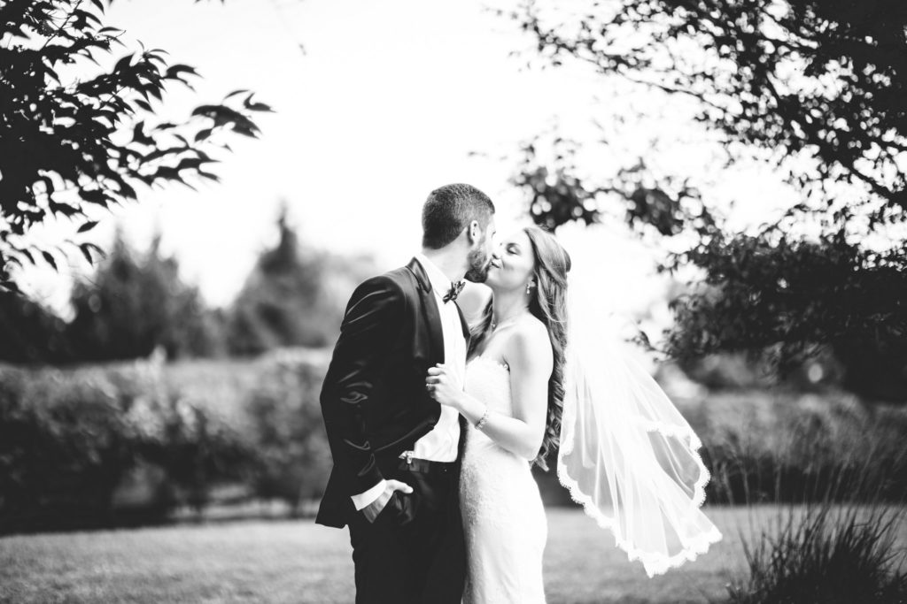 bride and groom kiss during first look at rose bank winery