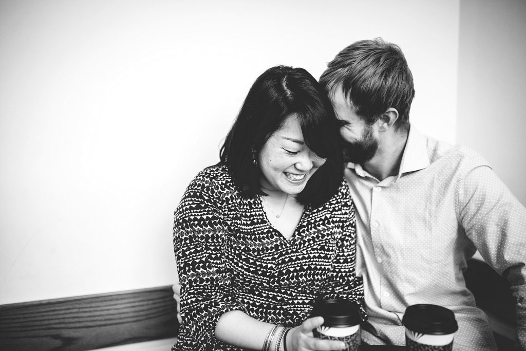 couple embrace at a coffee shop during their engagement session in philadelphia