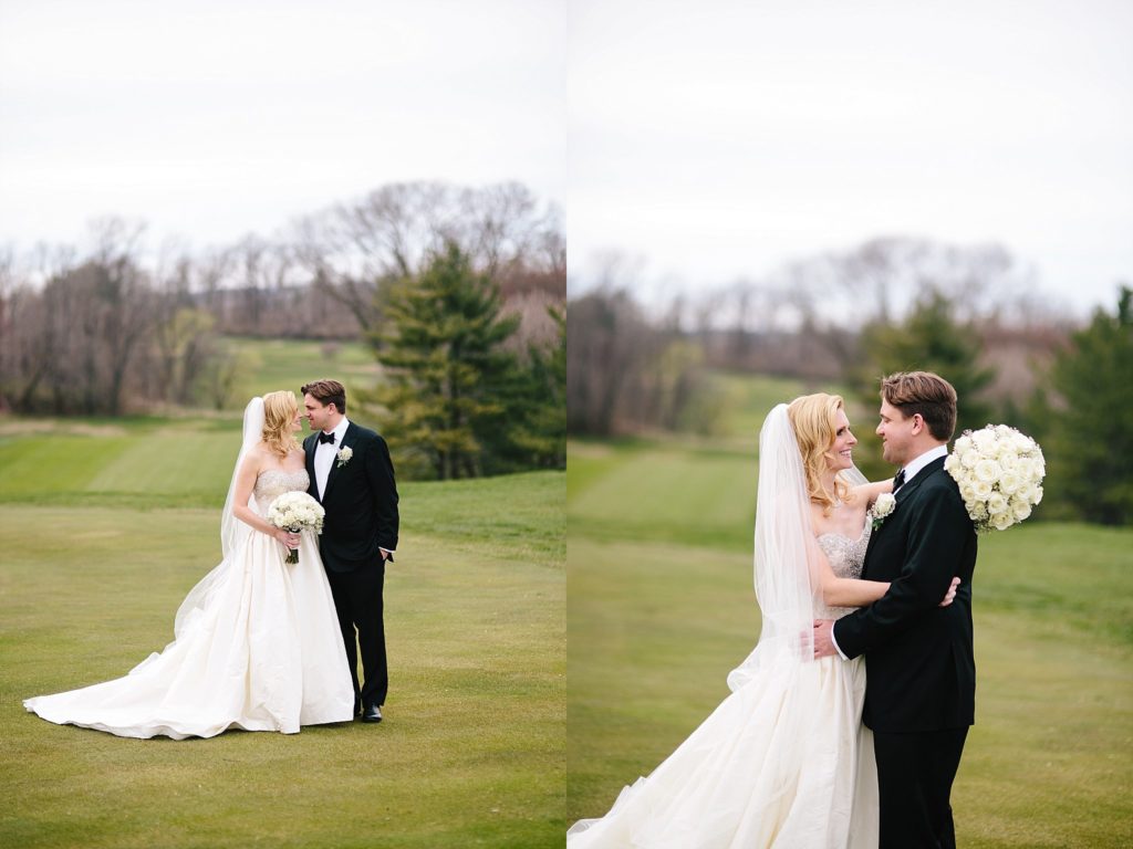 bride and groom embrace on the greens at Gulph Mills Golf Club outside of Philadelphia for their spring wedding
