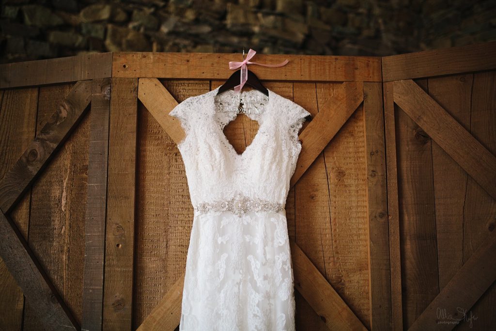 brides wedding dress against a barn door