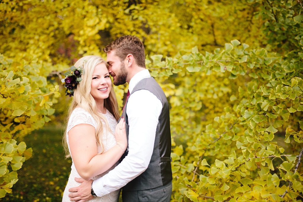 bride and groom kiss in the yellow autumn leaves of the ginkgo tree at tyler arboretum