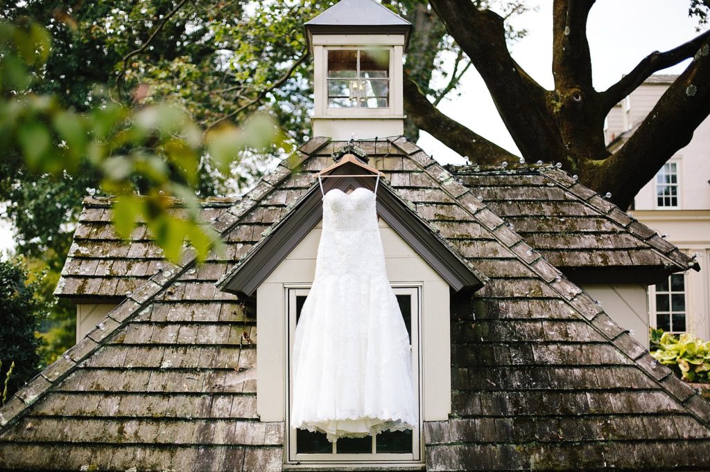 Bride's wedding dress hangs from the roof at Grace Winery