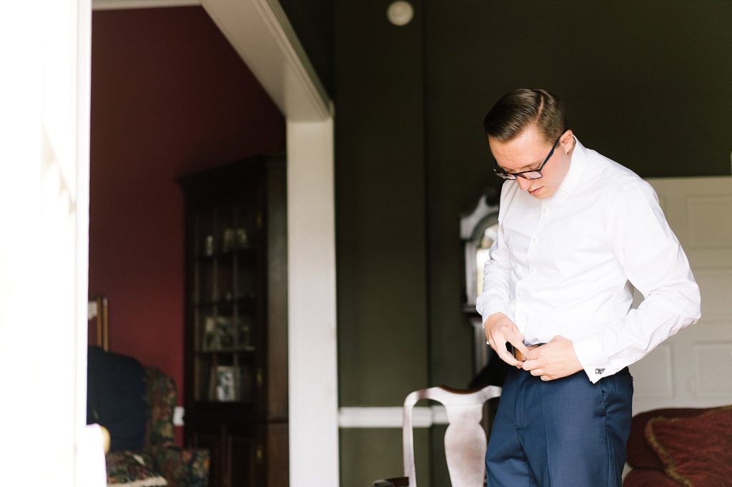 groom gets dressed before his wedding at Grace Winery in Glen Mills, PA