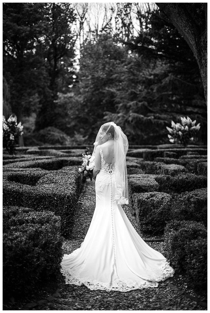 bride and groom pose for portraits in the gardens at Appleford Estate in Villanova PA during their summer wedding photographed by Allie Skylar Photography