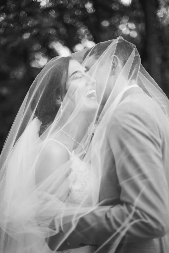 bride and groom kiss under the bride's veil at Belle Voir Manor at Pen Ryn Estate