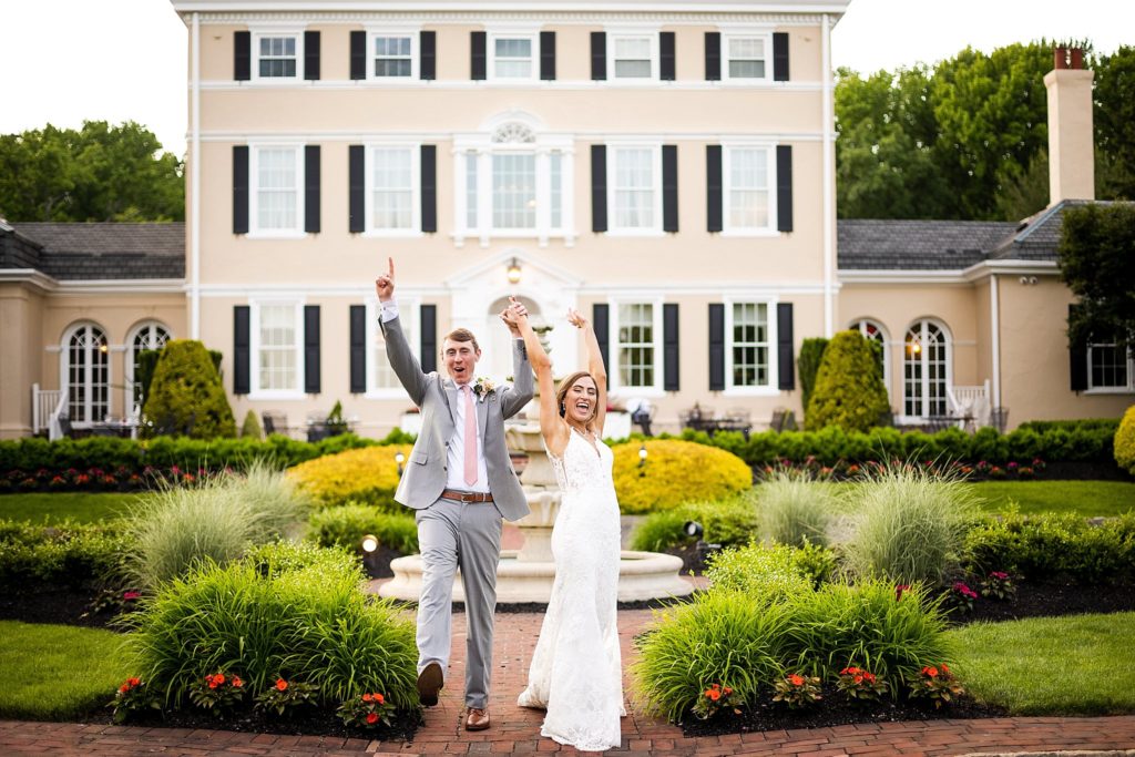 bride and groom celebrate in front of the mansion at Pen Ryn estate