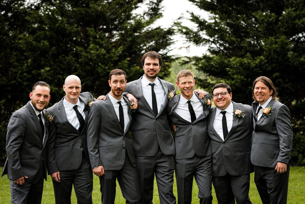groom poses with groomsmen at the barn at boones dam